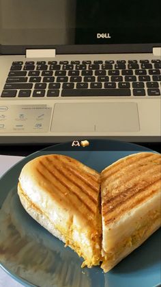 a heart shaped grilled cheese sandwich on a plate next to an open laptop computer