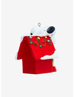 a snoopy dog house ornament hanging from a chain on a white background