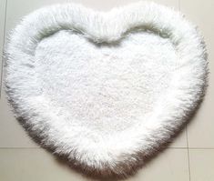 a white heart shaped rug on the floor