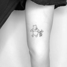 a black and white photo of a person with a tattoo on their leg