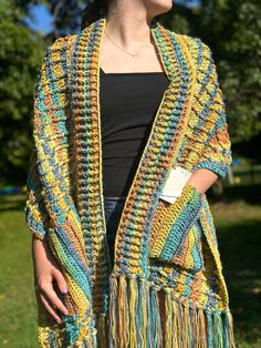 Trendy, boho inspired, multicolored pocket shawl. This fun-colorful design boasts 10 inches of flirty fringe on either end of the shawl.  Full length: 66 inches ( not including the 10 inches of fringe on either end) Width: 16 inches Care: wash in cold water on gentle cycle, lay flat or hang to dry Multicolor Fringed Shawl For Winter, Multicolor Fringe Shawl For Winter, Winter Multicolor Fringed Shawl, Fall Multicolor Fringe Shawl, Hippie Multicolor Scarf One Size, Multicolor Tassel Shawl For Fall, Bohemian Multicolor Poncho With Scarf, Multicolor Bohemian Poncho With Scarf, Multicolor Poncho Shawl With Scarf Detail