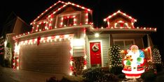 a house decorated for christmas with lights and decorations on the front yard, including a santa clause