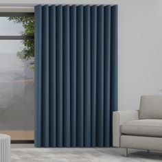 a living room with a couch, chair and window covered in blue vertical blind blinds