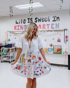 a woman in a white dress is posing for the camera with her hands on her hips