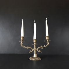 three candles are lit on a black table