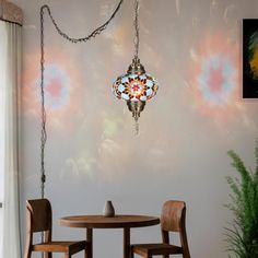 a dining room table with two chairs and a chandelier hanging from the ceiling