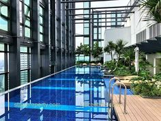 an empty swimming pool in the middle of a building with lots of plants and trees