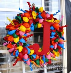 a colorful wreath with the letter j on it is in front of a building window