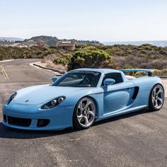 a blue sports car is parked on the road