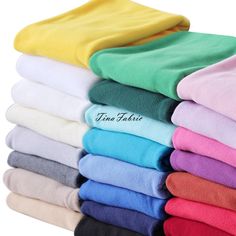 many colors of towels stacked on top of each other with the words ten fabric written across them