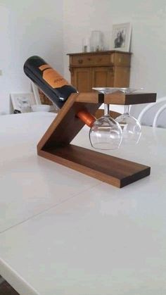 a wine glass holder on top of a table with a bottle and glasses in it