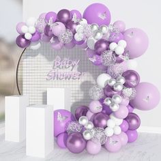 a bunch of balloons that are in the shape of a baby shower sign on a wall