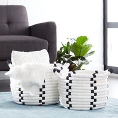 two black and white baskets sitting on top of a blue rug