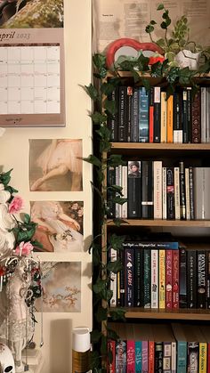 a bookshelf filled with lots of books next to a wall covered in pictures