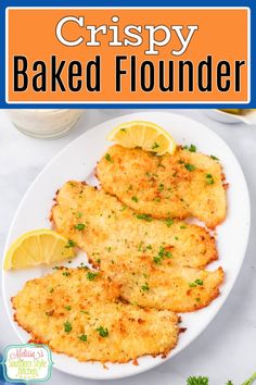 crispy baked fish fillets on a white plate with lemon wedges