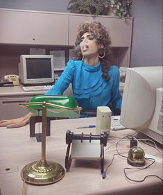 a woman sitting at a desk in front of a computer