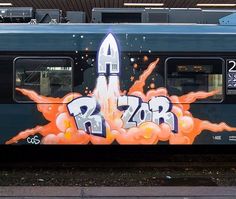 the side of a train with graffiti on it and a rocket painted on the side