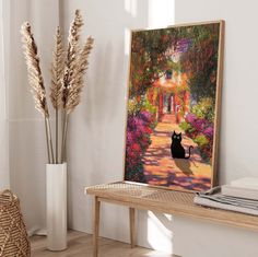 a black cat sitting on top of a wooden table next to a vase filled with flowers