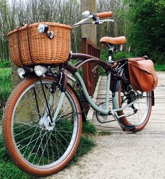 a bicycle with a basket parked on the side of a wooden walkway in front of some trees