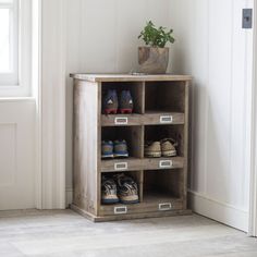 a wooden shelf with shoes on it in front of a door