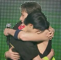 two people hugging each other on stage