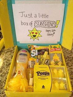 a yellow box filled with lots of different items next to a sign that says just a little box of sunshine