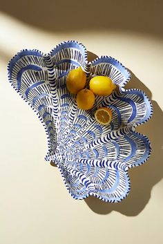 a blue and white bowl with lemons in it