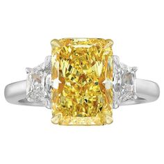 a fancy yellow diamond ring with three diamonds