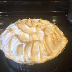 a cake with white frosting sitting on top of a table