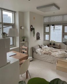 a bed room with a neatly made bed next to two windows and a desk in front of it