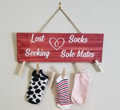 three pairs of socks hanging on a clothes line with the words, lost socks seeking sole mates