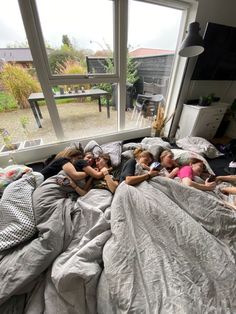 four girls are sleeping in their bed with the covers pulled back and sheets rolled down