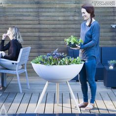 two women are sitting at a table with some plants