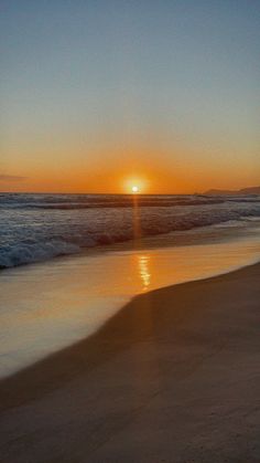 the sun is setting over the water at the beach