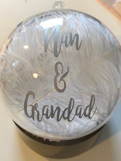 a clear glass plate with the words man and grandad written on it, sitting on a table