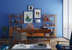 an office with blue walls and wooden shelves on either side of the desk is a white chair