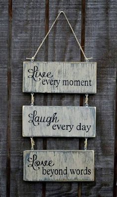 three wooden signs hanging on the side of a fence that says, love every moment laugh every day ignore beyond words