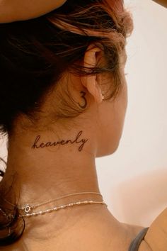 a woman with a tattoo on her neck that says heavenly behind her ear and the word'heaven'written in cursive font