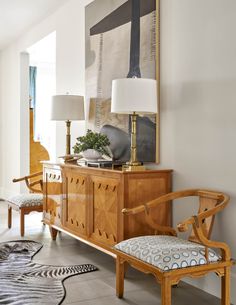 a living room filled with furniture and a painting on the wall