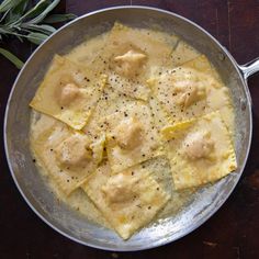 a pan filled with ravioli on top of a wooden table