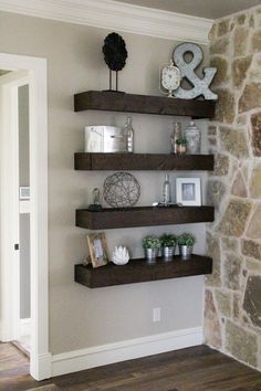 some shelves in the corner of a room with pictures and decorations on top of them