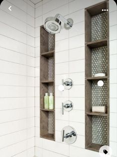 the shower head and shelves in this bathroom are made out of wooden planks, with white tile on the walls