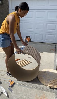 a woman in yellow shirt working on an outdoor furniture set with wood planks and plywood