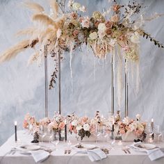 the table is set with flowers, candles and place settings for an elegant wedding reception