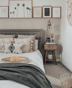 a bed sitting in a bedroom next to a wall with pictures hanging on the walls