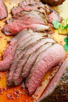 sliced meat sitting on top of a wooden cutting board