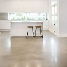 an empty kitchen with two stools in it