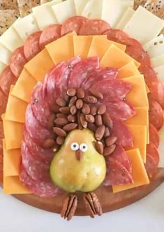 a turkey shaped plate with meat, cheese and nuts