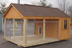 a small wooden dog house with a fence around it