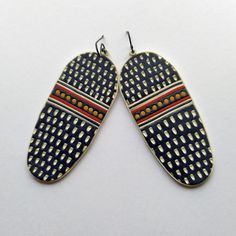 two pairs of earrings are shown on a white surface, one is blue and the other is red